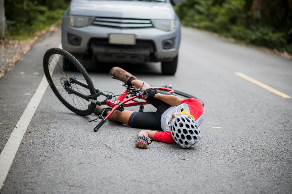 An injured bicyclist lies on the ground after being hit by a car on a Pennsylvania road.