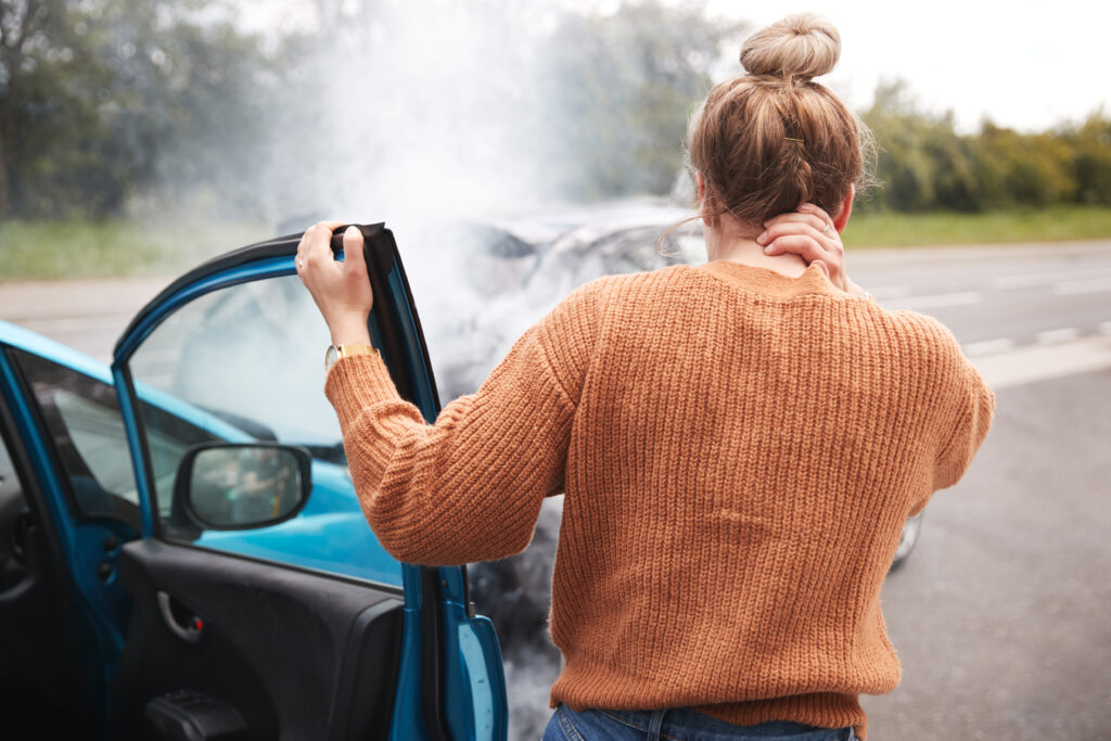 injured women standing by car after a car accident