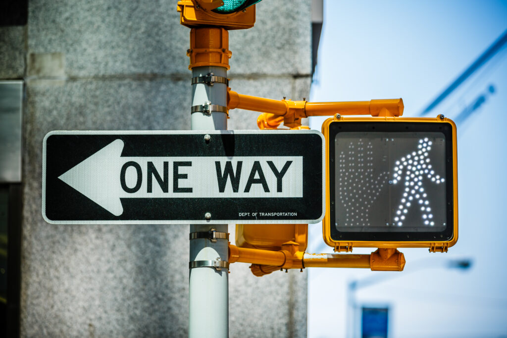 One way sign with green pedestrian traffic light