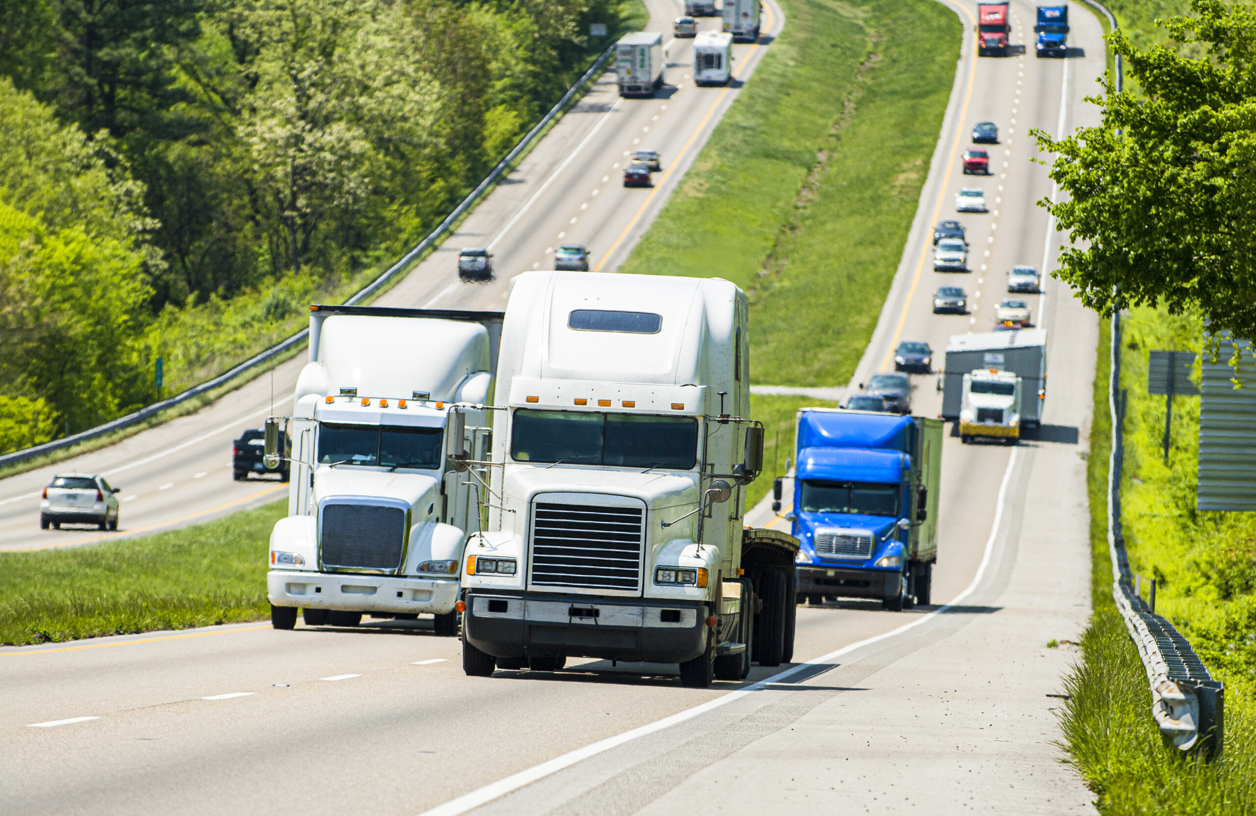 Horizontal shot of trucks on a busy highway.