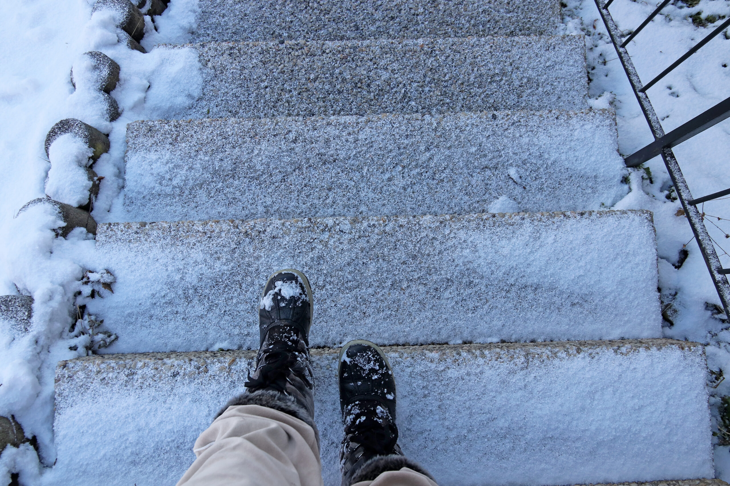 A person is in danger of an accident on a snow-covered stairway in winter.