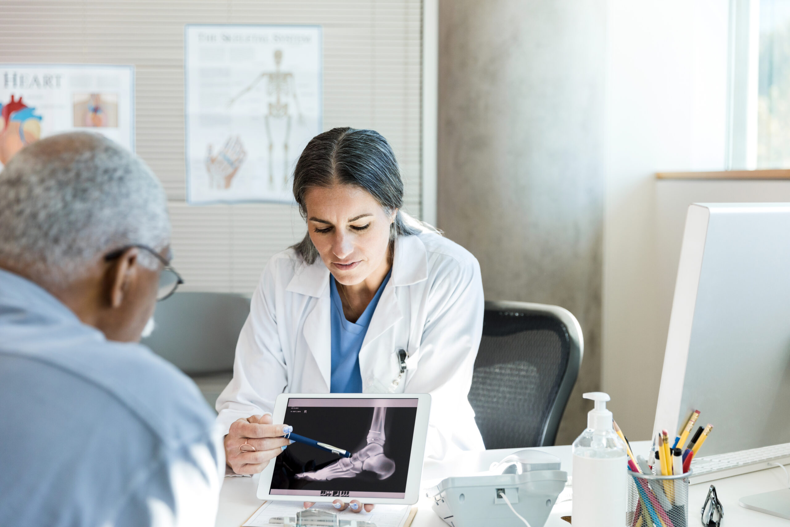 A doctor reviews an x-ray on a digital tablet with a personal injury victim.