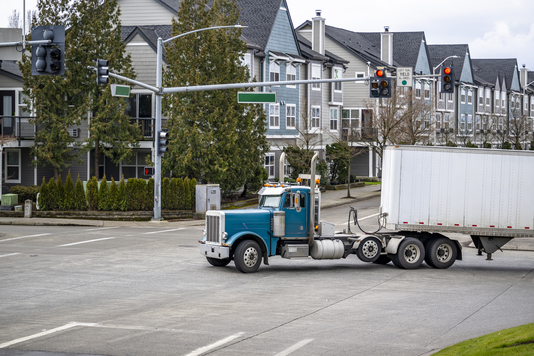 A large truck takes a wide turn at an intersection, crossing many lanes of traffic.